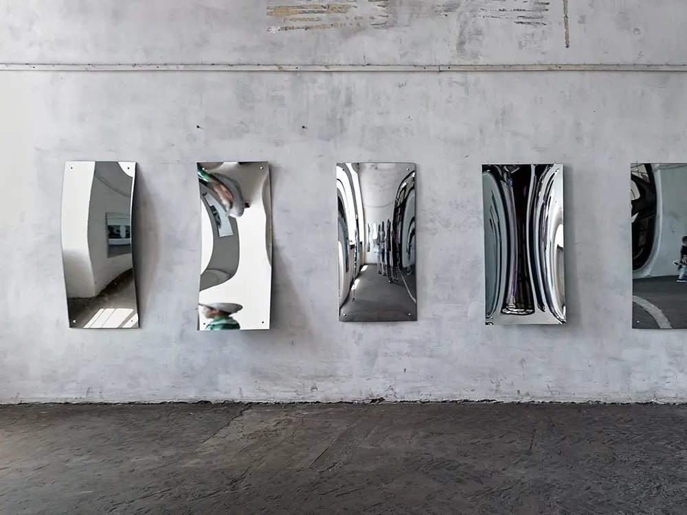 Mirrors on a wall with different curvatures where light is being bent, akin to the modulation of an RF carrier signal